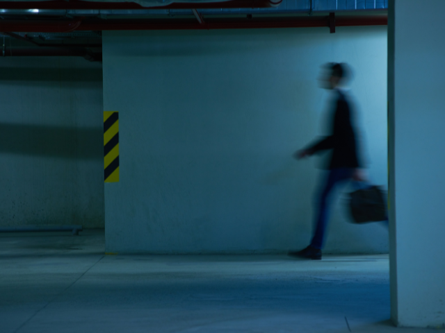 Shadow of person walking in dark parking garage.